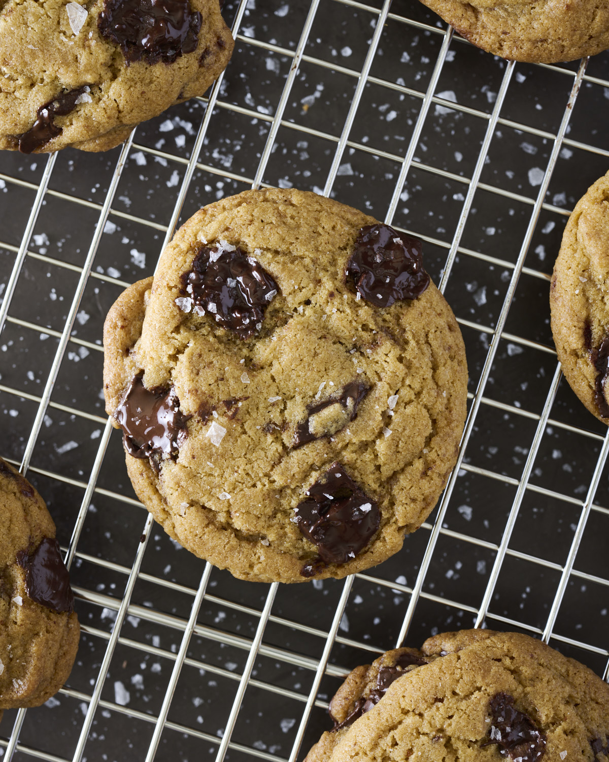 Close-up of a homemade Brown Butter Chocolate Chunk Cookie with crisp edges and melted chocolate chunks on a cooling rack.