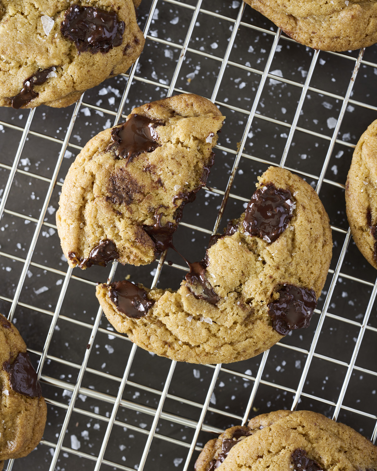 Homemade Brown Butter Chocolate Chunk Cookies arranged on a cooling rack in a rustic baking scene.