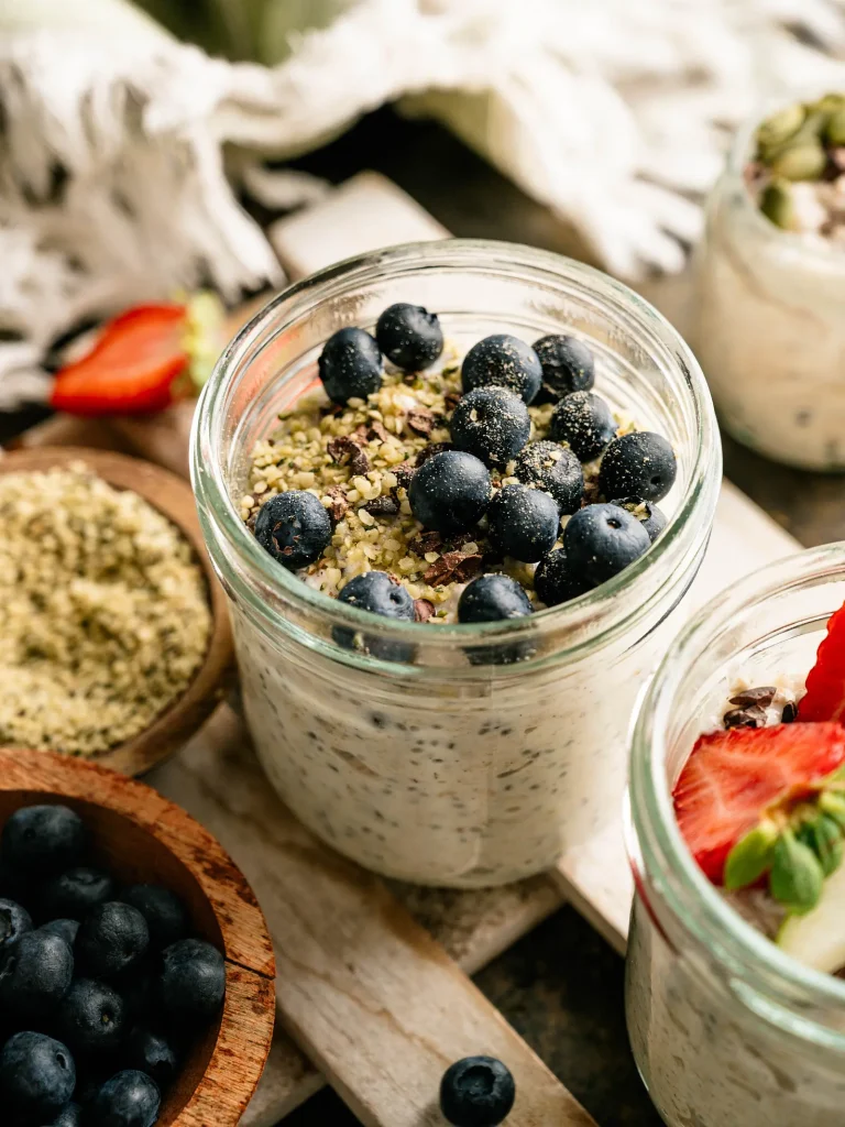 Creamy kefir overnight oats topped with blueberries and seeds in a glass jar